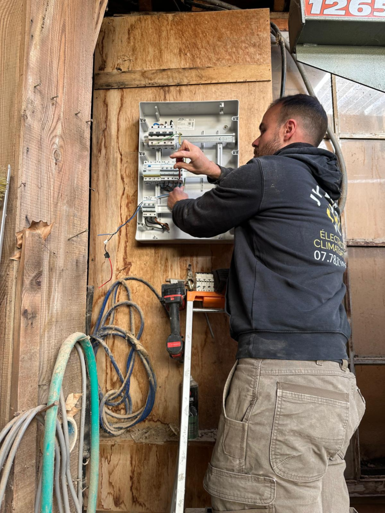 Électricien installant une prise électrique dans une nouvelle maison assemblage du réseau électrique JV Elec 32